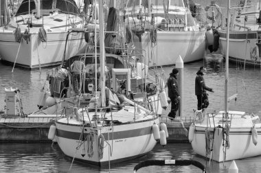 İtalya, Sicilya, Akdeniz, Marina di Ragusa (Ragusa Eyaleti); 2 Mart 2021, limandaki insanlar ve yelkenliler - EDITORIAL