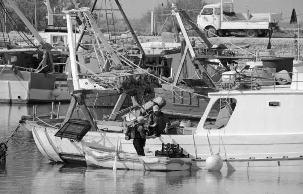 İtalya, Sicilya, Scoglitti (Ragusa Eyaleti), 9 Mart 2021, balıkçılar ve limanda yerel ahşap balıkçı tekneleri - EDITORIAL