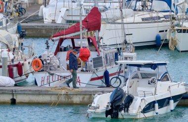 İtalya, Sicilya, Akdeniz, Marina di Ragusa (Ragusa Eyaleti); 16 Mart 2021, limandaki insanlar ve lüks yatlar - EDITORIAL