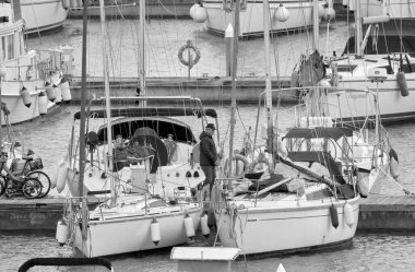 İtalya, Sicilya, Akdeniz, Marina di Ragusa (Ragusa Eyaleti); 16 Mart 2021, limandaki insanlar ve lüks yatlar - EDITORIAL