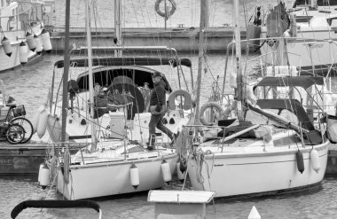 İtalya, Sicilya, Akdeniz, Marina di Ragusa (Ragusa Eyaleti); 16 Mart 2021, limandaki insanlar ve lüks yatlar - EDITORIAL