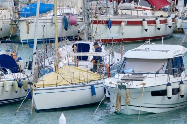 İtalya, Sicilya, Akdeniz, Marina di Ragusa (Ragusa Eyaleti); 16 Mart 2021, limandaki insanlar ve lüks yatlar - EDITORIAL