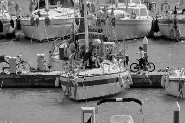 İtalya, Sicilya, Akdeniz, Marina di Ragusa (Ragusa Eyaleti); 17 Mart 2021, limandaki insanlar ve lüks yatlar - EDITORIAL