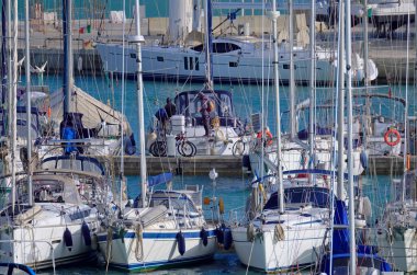 İtalya, Sicilya, Akdeniz, Marina di Ragusa (Ragusa ili); 17 Mart 2021, limandaki insanlar ve yelkenliler - EDITORIAL