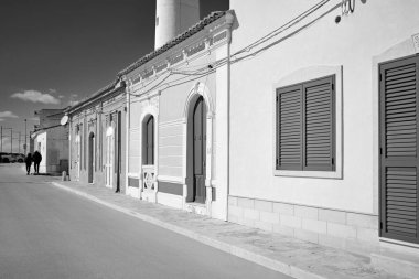 İtalya, Sicilya, Akdeniz, Punta Secca (Ragusa Eyaleti), insanlar, deniz kenarında ve deniz fenerinde eski bir Sicilya barok evinin cephesi