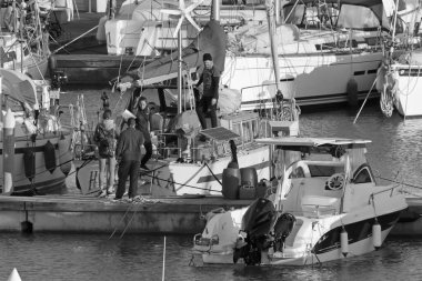 İtalya, Sicilya, Akdeniz, Marina di Ragusa (Ragusa Eyaleti); 24 Mart 2021, limandaki insanlar ve lüks yatlar - EDITORIAL