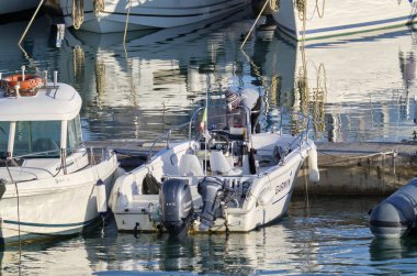 İtalya, Sicilya, Akdeniz, Marina di Ragusa (Ragusa Eyaleti); 27 Mart 2021, limandaki bir motorlu teknede adam - EDITORIAL