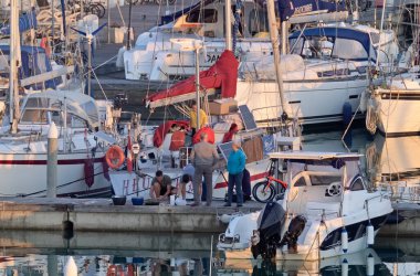 İtalya, Sicilya, Akdeniz, Marina di Ragusa (Ragusa Eyaleti); 30 Mart 2021, limandaki insanlar ve lüks yatlar - EDITORIAL