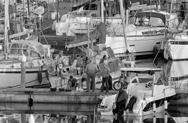 İtalya, Sicilya, Akdeniz, Marina di Ragusa (Ragusa Eyaleti); 30 Mart 2021, limandaki insanlar ve lüks yatlar - EDITORIAL