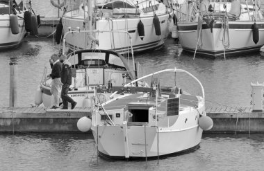 İtalya, Sicilya, Akdeniz, Marina di Ragusa (Ragusa ili); 31 Mart 2021, limandaki insanlar ve yelkenliler - EDITORIAL