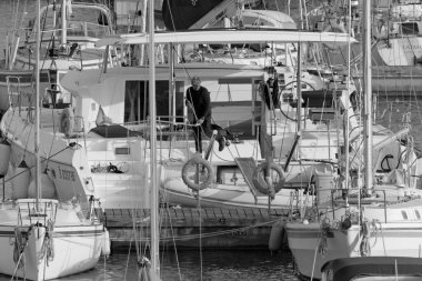 İtalya, Sicilya, Akdeniz, Marina di Ragusa (Ragusa Eyaleti); 31 Mart 2021, büyük bir yelkenli teknesi ve limandaki lüks yatlarda adam - EDITORIAL