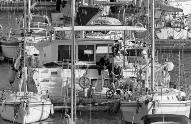 İtalya, Sicilya, Akdeniz, Marina di Ragusa (Ragusa Eyaleti); 1 Nisan 2021, limandaki büyük bir yelkenli teknesinde insanlar - EDITORIAL