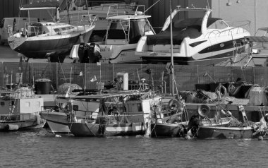 İtalya, Sicilya, Marina di Ragusa (Ragusa Eyaleti), 6 Nisan 2021, limanda yerel balıkçı tekneleri ve lüks yatlar - EDITORIAL