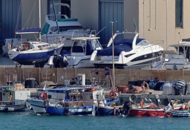 İtalya, Sicilya, Marina di Ragusa (Ragusa Eyaleti), 6 Nisan 2021, limanda yerel balıkçı tekneleri ve lüks yatlar - EDITORIAL