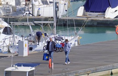 İtalya, Sicilya, Akdeniz, Marina di Ragusa (Ragusa Eyaleti); 8 Nisan 2021, limandaki insanlar ve lüks yatlar - EDITORIAL