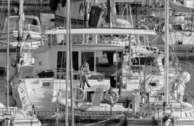 İtalya, Sicilya, Akdeniz, Marina di Ragusa (Ragusa Eyaleti); 10 Nisan 2021, limandaki büyük bir yelkenli teknesinde kadın - EDITORIAL