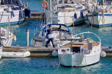 İtalya, Sicilya, Akdeniz, Marina di Ragusa (Ragusa Eyaleti); 13 Nisan 2021, limandaki insanlar ve lüks yatlar - EDITORIAL