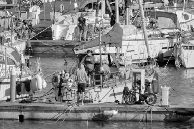 İtalya, Sicilya, Akdeniz, Marina di Ragusa (Ragusa Eyaleti); 17 Nisan 2021, limandaki insanlar ve lüks yatlar - EDITORIAL