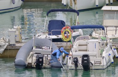 İtalya, Sicilya, Akdeniz, Marina di Ragusa (Ragusa Eyaleti); 23 Nisan 2021, limandaki bir kauçuk teknede adam - EDITORIAL