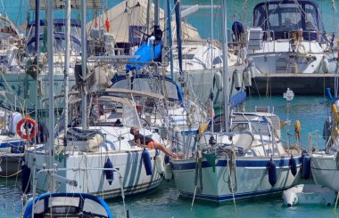 İtalya, Sicilya, Akdeniz, Marina di Ragusa (Ragusa Eyaleti); 25 Nisan 2021, limandaki insanlar ve lüks yatlar - EDITORIAL