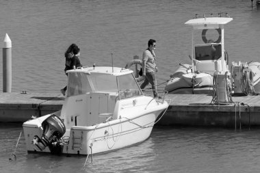 İtalya, Sicilya, Akdeniz, Marina di Ragusa (Ragusa ili); 25 Nisan 2021, limanda insanlar ve motorlu tekneler - EDITORIAL