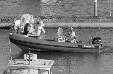 İtalya, Sicilya, Akdeniz, Marina di Ragusa (Ragusa Eyaleti); 28 Nisan 2021, limandaki kauçuk bir teknede adam - EDITORIAL