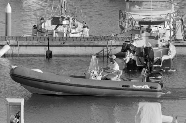 İtalya, Sicilya, Akdeniz, Marina di Ragusa (Ragusa Eyaleti); 28 Nisan 2021, limandaki kauçuk bir teknede adam - EDITORIAL