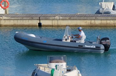 İtalya, Sicilya, Akdeniz, Marina di Ragusa (Ragusa Eyaleti); 28 Nisan 2021, limandaki kauçuk bir teknede adam - EDITORIAL