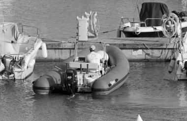 İtalya, Sicilya, Akdeniz, Marina di Ragusa (Ragusa Eyaleti); 28 Nisan 2021, limandaki kauçuk bir teknede adam - EDITORIAL