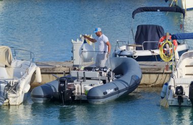 İtalya, Sicilya, Akdeniz, Marina di Ragusa (Ragusa Eyaleti); 28 Nisan 2021, limandaki kauçuk bir teknede adam - EDITORIAL