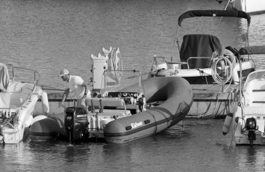 İtalya, Sicilya, Akdeniz, Marina di Ragusa (Ragusa Eyaleti); 28 Nisan 2021, limandaki kauçuk bir teknede adam - EDITORIAL