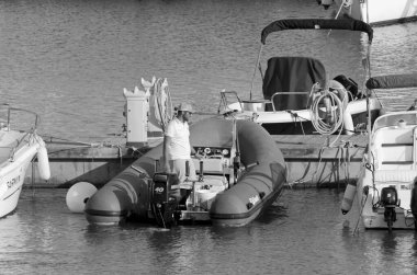 İtalya, Sicilya, Akdeniz, Marina di Ragusa (Ragusa Eyaleti); 28 Nisan 2021, limandaki kauçuk bir teknede adam - EDITORIAL