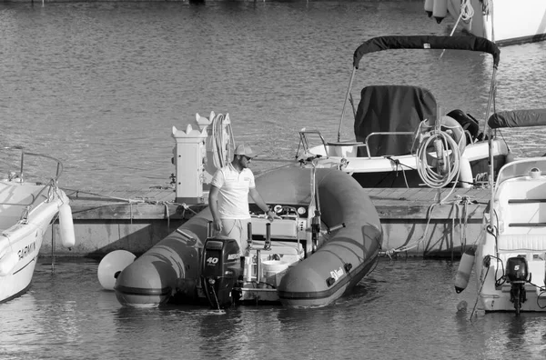 İtalya, Sicilya, Akdeniz, Marina di Ragusa (Ragusa Eyaleti); 28 Nisan 2021, limandaki kauçuk bir teknede adam - EDITORIAL