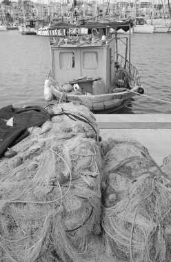 İtalya, Sicilya, Marina di Ragusa (Ragusa Eyaleti), limandaki balıkçı tekneleri, balıkçı ağları ve lüks yatlar 