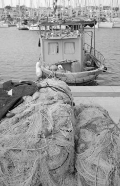 İtalya, Sicilya, Marina di Ragusa (Ragusa Eyaleti), limandaki balıkçı tekneleri, balıkçı ağları ve lüks yatlar 