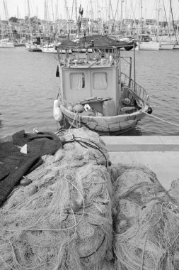 İtalya, Sicilya, Marina di Ragusa (Ragusa Eyaleti), limandaki balıkçı tekneleri, balıkçı ağları ve lüks yatlar 