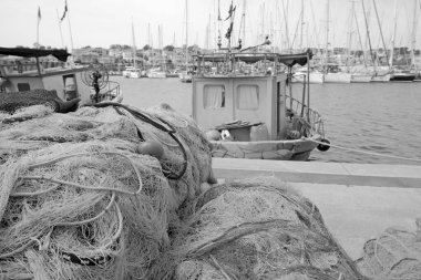 İtalya, Sicilya, Marina di Ragusa (Ragusa Eyaleti), limandaki balıkçı tekneleri, balıkçı ağları ve lüks yatlar 