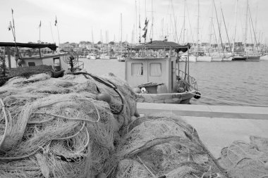 İtalya, Sicilya, Marina di Ragusa (Ragusa Eyaleti), limandaki balıkçı tekneleri, balıkçı ağları ve lüks yatlar 