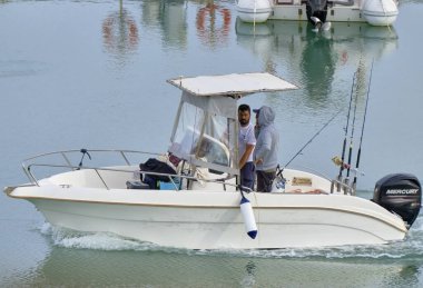 İtalya, Sicilya, Akdeniz, Marina di Ragusa (Ragusa ili); 5 Mayıs 2021, limandaki bir motorlu teknede balıkçılar - EDITORIAL