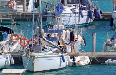 İtalya, Sicilya, Akdeniz, Marina di Ragusa (Ragusa ili); 12 Mayıs 2021, limanda insanlar ve yelkenliler - EDITORIAL