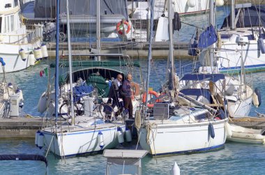 İtalya, Sicilya, Akdeniz, Marina di Ragusa (Ragusa Eyaleti); 13 Mayıs 2021, limandaki insanlar ve lüks yatlar - EDITORIAL