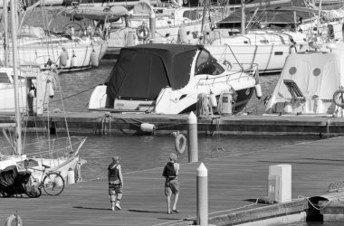 İtalya, Sicilya, Akdeniz, Marina di Ragusa (Ragusa Eyaleti); 16 Mayıs 2021, limandaki insanlar ve lüks yatlar - EDITORIAL