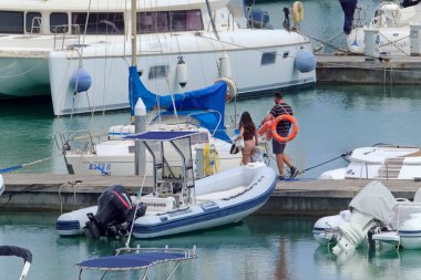 İtalya, Sicilya, Akdeniz, Marina di Ragusa (Ragusa ili); 5 Haziran 2021, limandaki insanlar, motorlu tekneler ve lüks yatlar - EDITORIAL