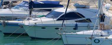 İtalya, Sicilya, Akdeniz, Marina di Ragusa (Ragusa Eyaleti); 12 Haziran 2021, limandaki bir yelkenli ve lüks yatlarda adam - EDITORIAL