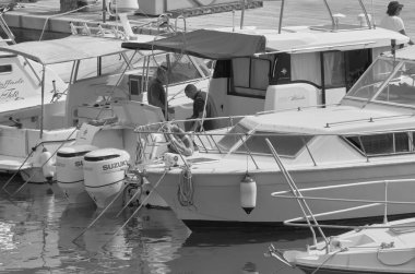 İtalya, Sicilya, Akdeniz, Marina di Ragusa (Ragusa Eyaleti); 12 Haziran 2021, erkekler limanda lüks bir yatta - EDITORIAL