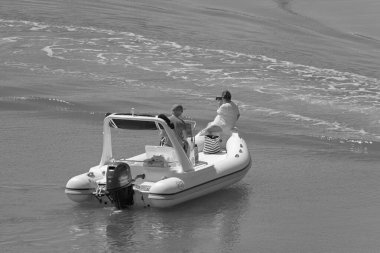 İtalya, Sicilya, Akdeniz, Marina di Ragusa (Ragusa ili); 13 Haziran 2021, limanda bir kauçuk teknede çift - EDITORIAL