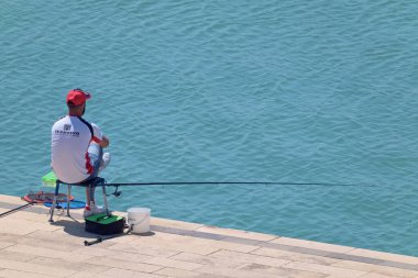 İtalya, Sicilya, Marina di Ragusa (Ragusa Eyaleti); 13 Haziran 2021, limanda balıkçılık yapan balıkçı - EDITORIAL