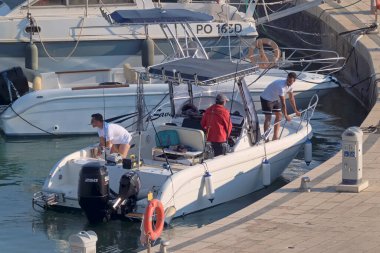 İtalya, Sicilya, Akdeniz, Marina di Ragusa (Ragusa Eyaleti); 13 Haziran 2021, limandaki bir motorlu teknede balıkçı - EDITORIAL