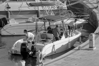 İtalya, Sicilya, Akdeniz, Marina di Ragusa (Ragusa Eyaleti); 13 Haziran 2021, limandaki bir motorlu teknede balıkçı - EDITORIAL