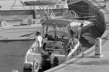 İtalya, Sicilya, Akdeniz, Marina di Ragusa (Ragusa Eyaleti); 13 Haziran 2021, limandaki bir motorlu teknede balıkçı - EDITORIAL